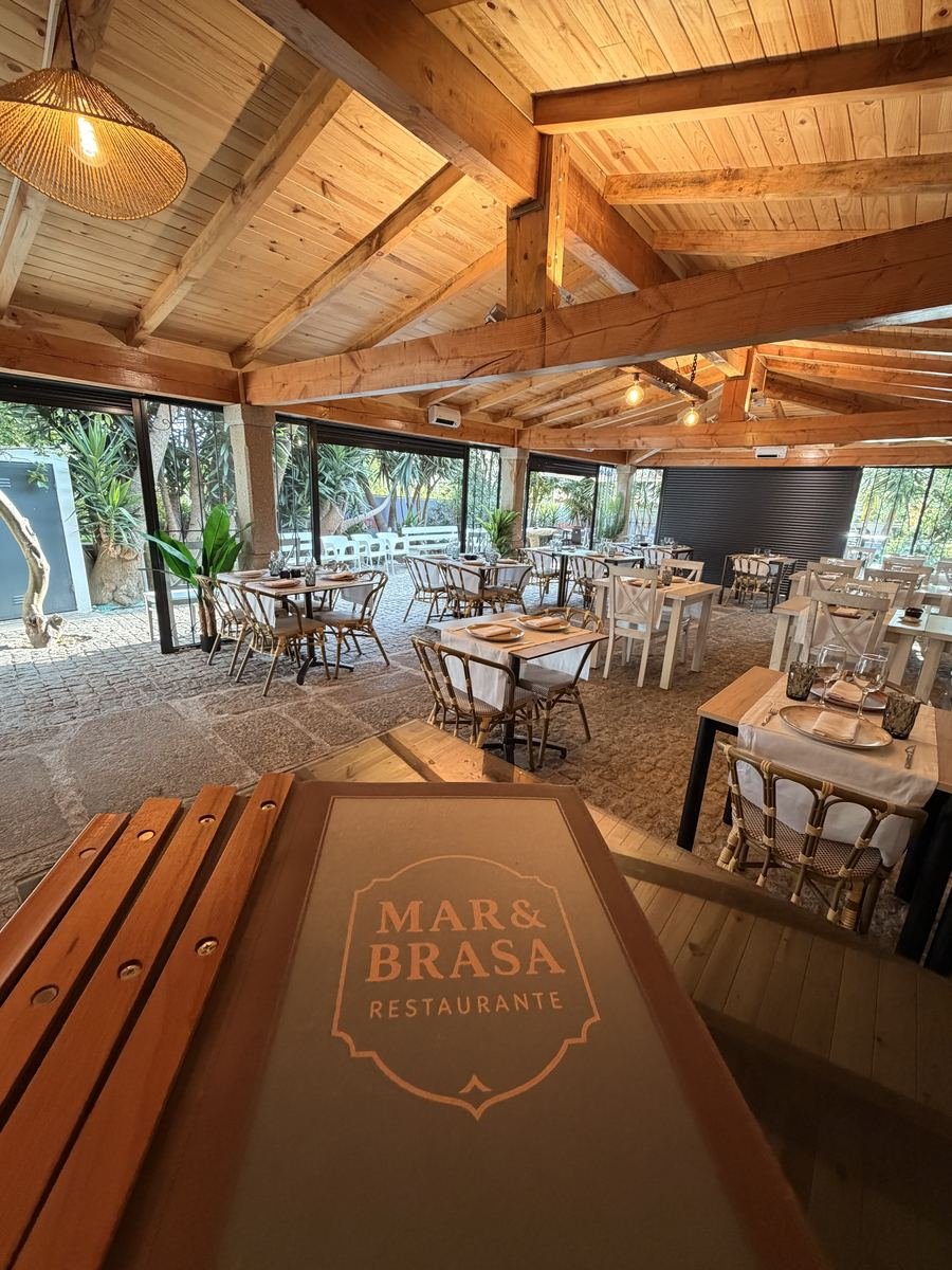 O pavilhão de madeira, com as mesas postas e o jardim lá fora