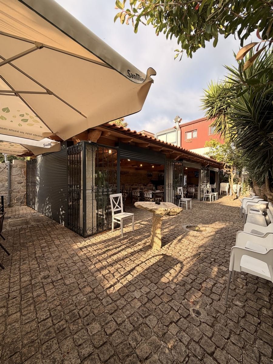 A esplanada, com o guarda-sol aberto sobre a calçada