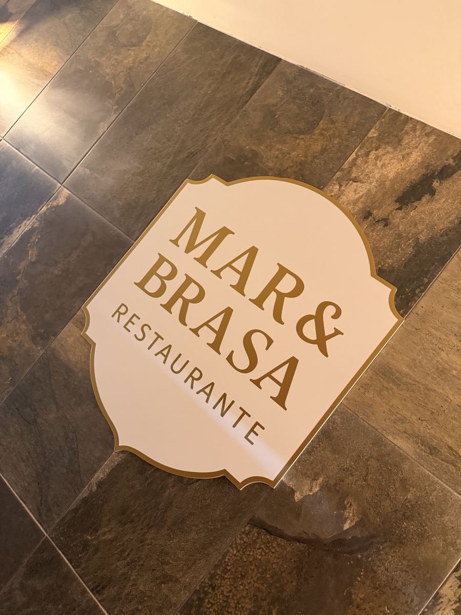 A placa do Mar & Brasa assente no chão de pedra